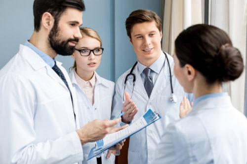 Pflegefachperson im Gespräch mit einem medizinischen Team